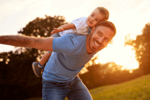 Father and son dancing together in nature.